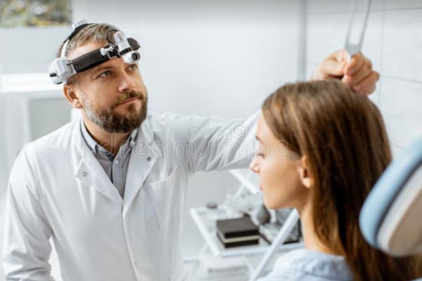 Audiologist Services An audiologist performing a hearing examination with a patient in a clinic in Estero, FL