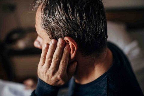 Person straining to hear due to sudden hearing loss