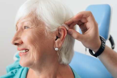 Individual adjusting their new hearing aid